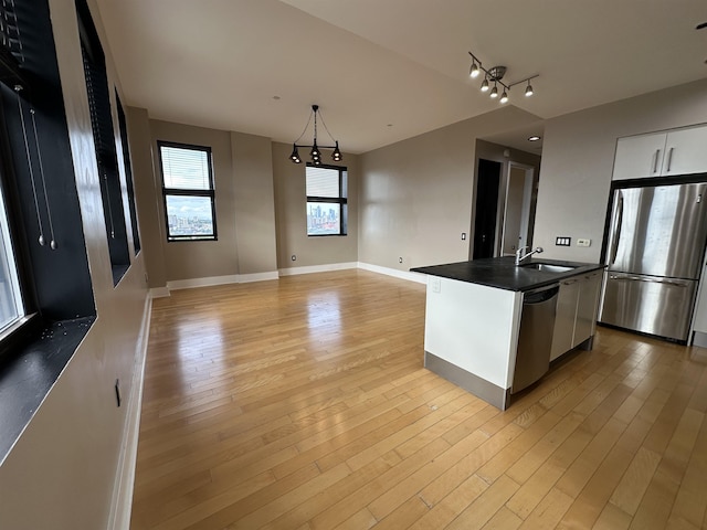 4 Beacon Way Unit 1001, Jersey City, NJ 07304 - kitchen with stainless steel appliances, a sink, dark countertops, light wood-style flooring, and white cabinetry