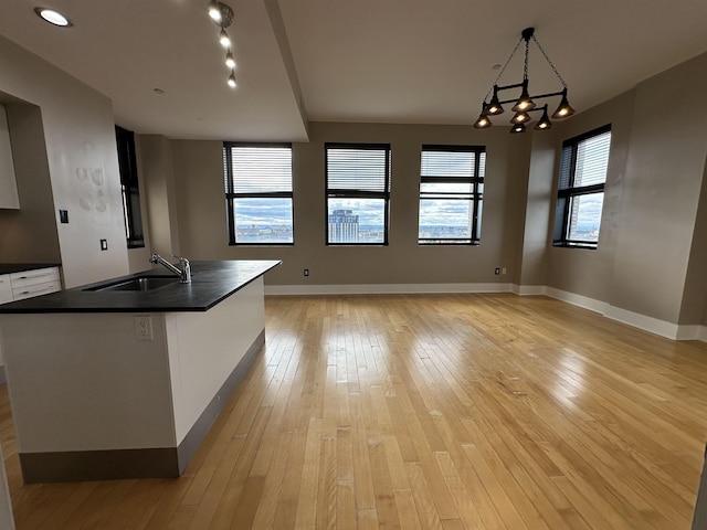 4 Beacon Way Unit 1001, Jersey City, NJ 07304 - kitchen with a sink, dark countertops, white cabinetry, and light wood-style flooring