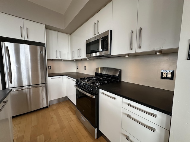 4 Beacon Way Unit 1001, Jersey City, NJ 07304 - kitchen featuring appliances with stainless steel finishes, dark countertops, white cabinetry, and light wood-type flooring
