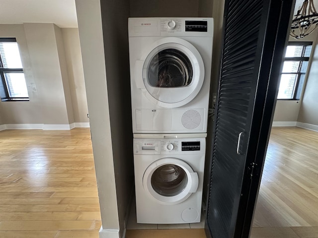 4 Beacon Way Unit 1001, Jersey City, NJ 07304 - laundry area featuring stacked washer / drying machine, light wood finished floors, and baseboards