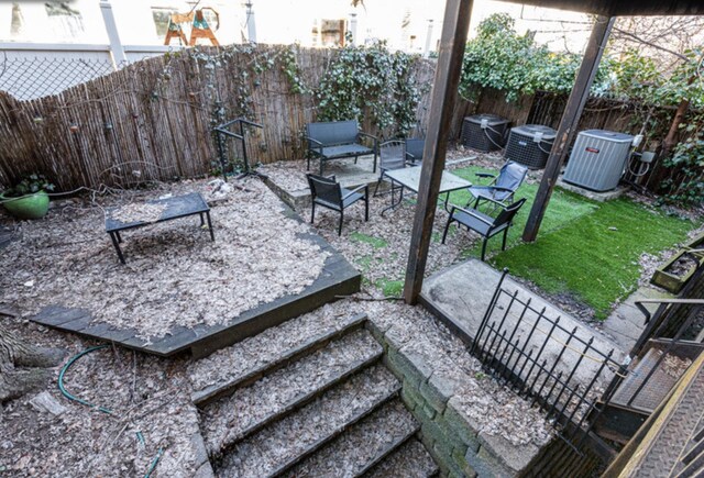 exterior space featuring central AC and a fenced backyard