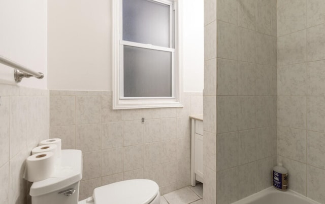 bathroom with wainscoting, tile walls, and toilet