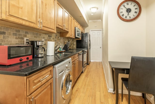 kitchen with stainless steel appliances, ornamental molding, light wood finished floors, washer / dryer, and tasteful backsplash