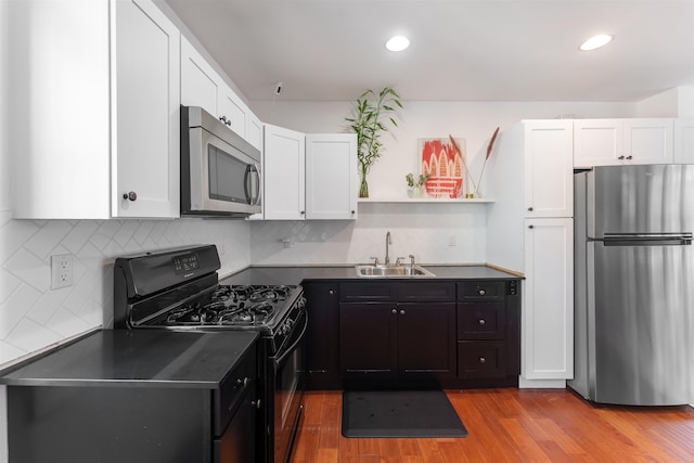 402 1st St, Jersey City, NJ 07302 - kitchen with stainless steel appliances, open shelves, dark countertops, a sink, and white cabinetry