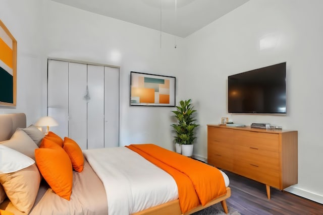 bedroom with dark hardwood / wood-style flooring and a towering ceiling