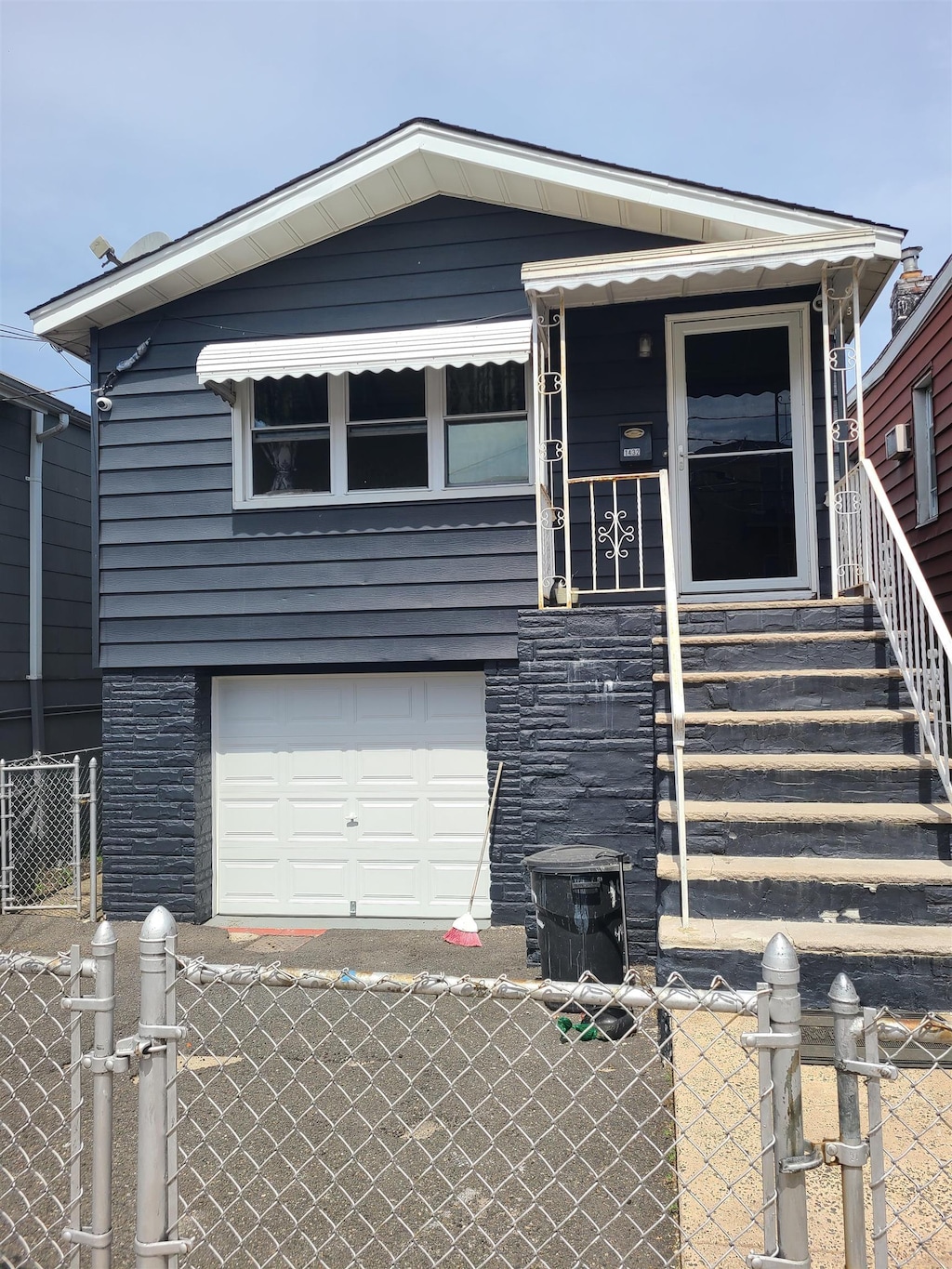 view of front facade featuring an attached garage, fence, and a gate