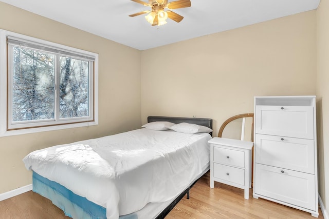 bedroom with baseboards, a ceiling fan, and light wood finished floors