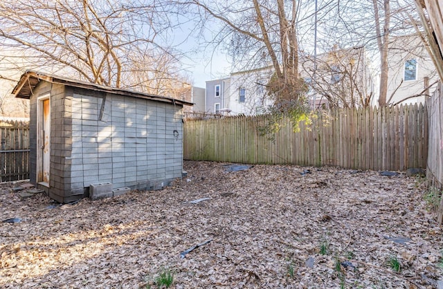 view of yard featuring an outbuilding, a fenced backyard, and a shed