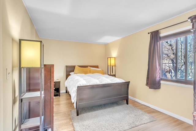 bedroom with light wood-type flooring and baseboards