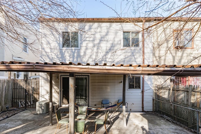 rear view of property with central AC, a fenced backyard, and a patio area