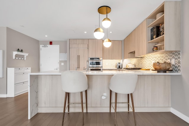 kitchen featuring tasteful backsplash, light countertops, built in fridge, and stainless steel double oven