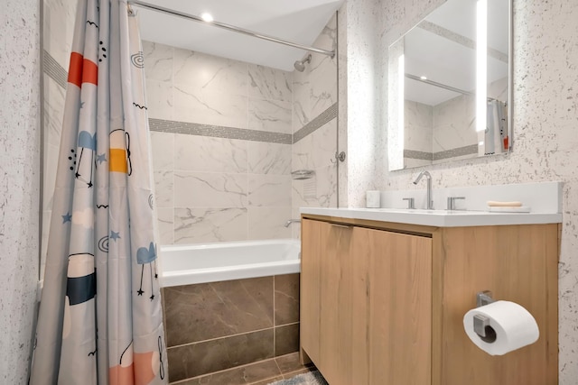 bathroom with tiled shower / bath combo and vanity