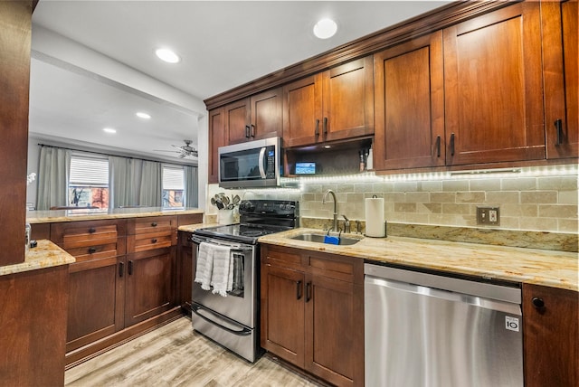 607 1st St Unit 1, Hoboken, NJ 07030 - kitchen with stainless steel appliances, a sink, light stone counters, light wood-style floors, and decorative backsplash