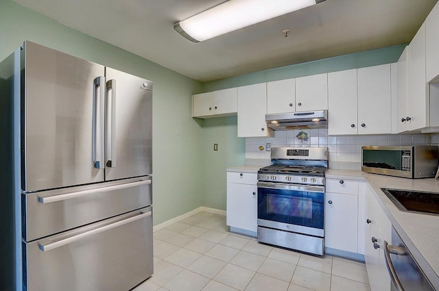 54 Polk St, Newark, NJ 07105 - kitchen featuring appliances with stainless steel finishes, under cabinet range hood, light countertops, and white cabinetry
