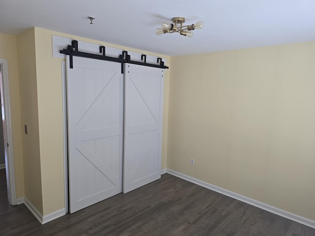 54 Polk St, Newark, NJ 07105 - unfurnished bedroom with dark wood-type flooring and a barn door