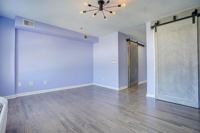 54 Polk St, Newark, NJ 07105 - unfurnished room featuring a barn door, wood finished floors, and a chandelier
