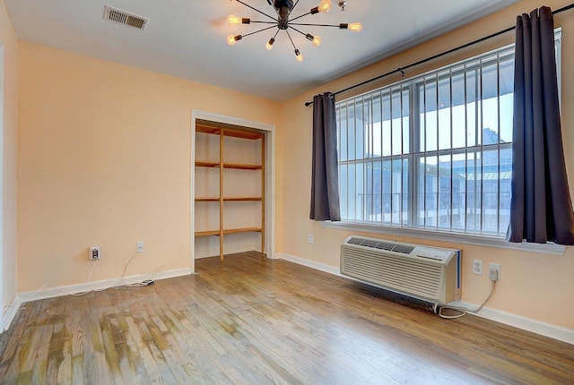 54 Polk St, Newark, NJ 07105 - empty room featuring a chandelier, wood finished floors, and an AC wall unit