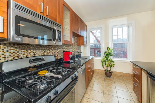 kitchen with light tile patterned floors, stainless steel appliances, sink, and backsplash