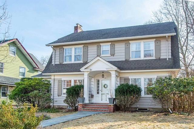 view of front of home with a chimney and a shingled roof