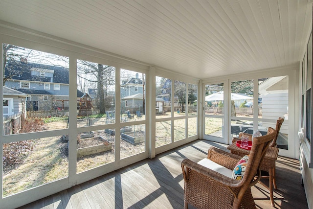 sunroom / solarium featuring a residential view and wooden ceiling