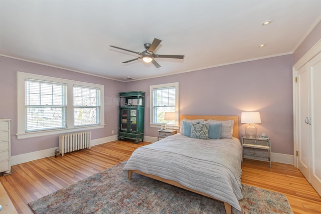 bedroom featuring crown molding, radiator heating unit, wood finished floors, and baseboards