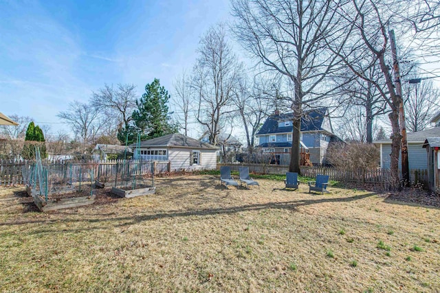 view of yard featuring a vegetable garden, an outdoor structure, and fence