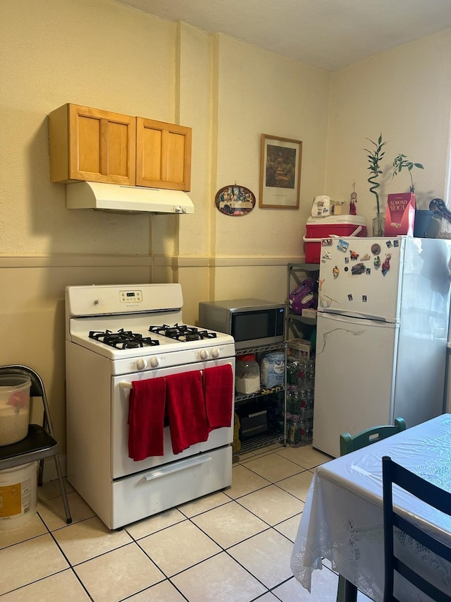 kitchen with white appliances and light tile patterned floors