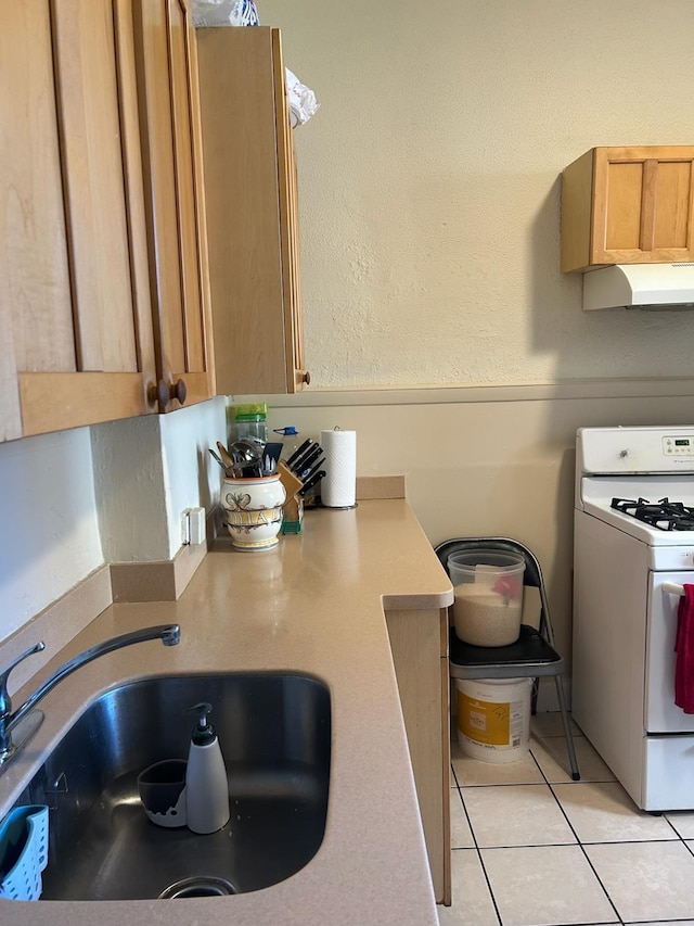 kitchen with sink, white gas stove, and light tile patterned floors