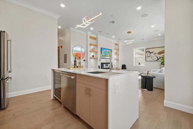 kitchen featuring decorative light fixtures, a kitchen island, crown molding, light wood-type flooring, and appliances with stainless steel finishes