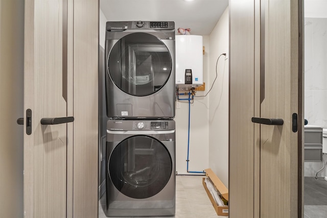 washroom with tankless water heater and stacked washer / dryer