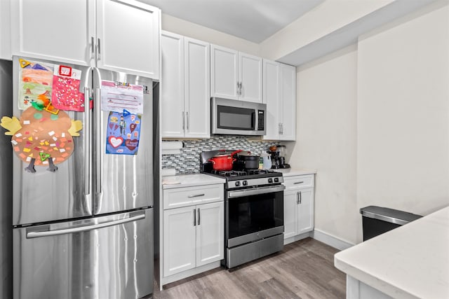 kitchen with stainless steel appliances, white cabinets, and light countertops