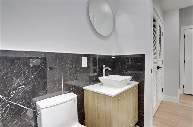 443 Bergen Ave Unit 3, Jersey City, NJ 07304 - bathroom featuring tile walls, vanity, a closet, and wood finished floors