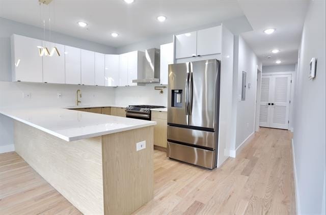 443 Bergen Ave Unit 3, Jersey City, NJ 07304 - kitchen with wall chimney range hood, appliances with stainless steel finishes, a peninsula, light wood-style floors, and recessed lighting
