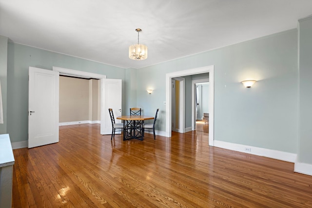 dining space featuring wood-type flooring and a notable chandelier