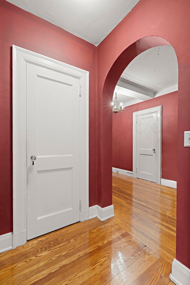 foyer entrance featuring wood-type flooring and an inviting chandelier