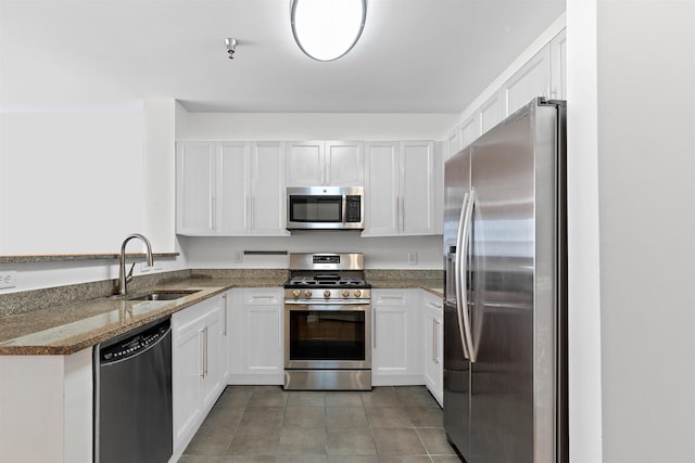 15 Enterprise Ct Unit 211, Jersey City, NJ 07305 - kitchen with dark stone counters, a sink, light tile patterned floors, white cabinets, and appliances with stainless steel finishes