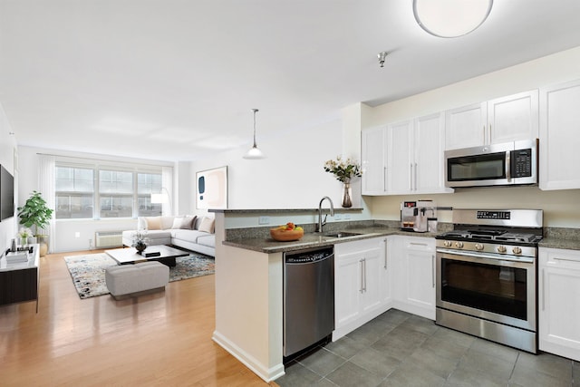 15 Enterprise Ct Unit 211, Jersey City, NJ 07305 - kitchen with a peninsula, stainless steel appliances, a sink, white cabinetry, and open floor plan