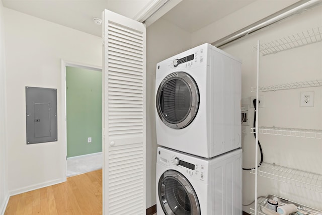 15 Enterprise Ct Unit 211, Jersey City, NJ 07305 - washroom with laundry area, stacked washer / dryer, electric panel, light wood finished floors, and baseboards