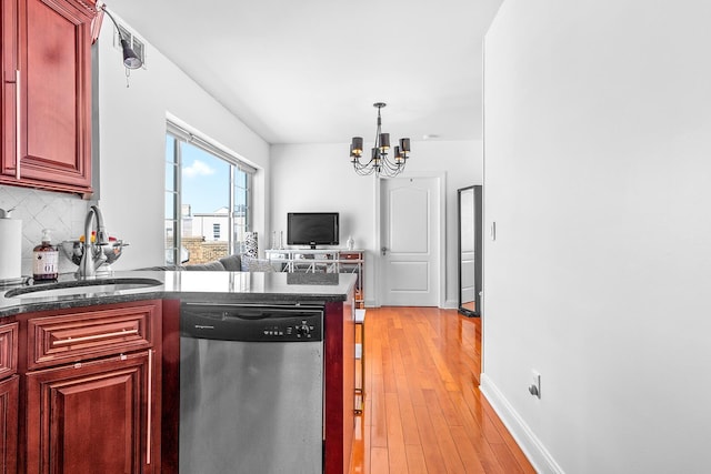 kitchen featuring a sink, reddish brown cabinets, an inviting chandelier, decorative backsplash, and dishwasher