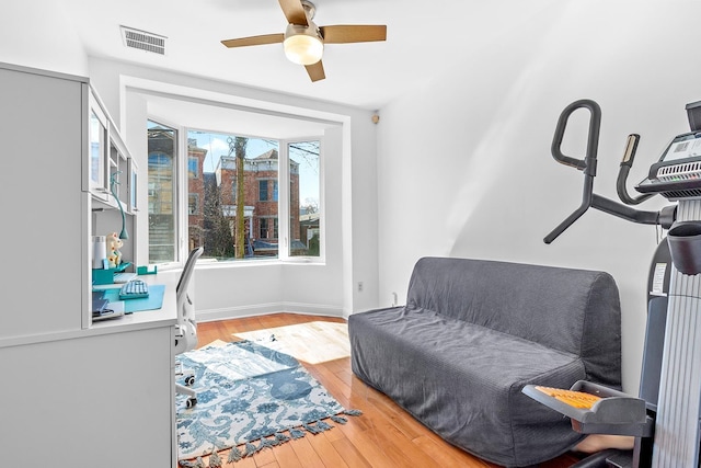 sitting room with visible vents, baseboards, a ceiling fan, and light wood finished floors