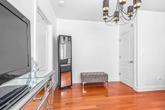 dining area with baseboards, light wood-style floors, and an inviting chandelier