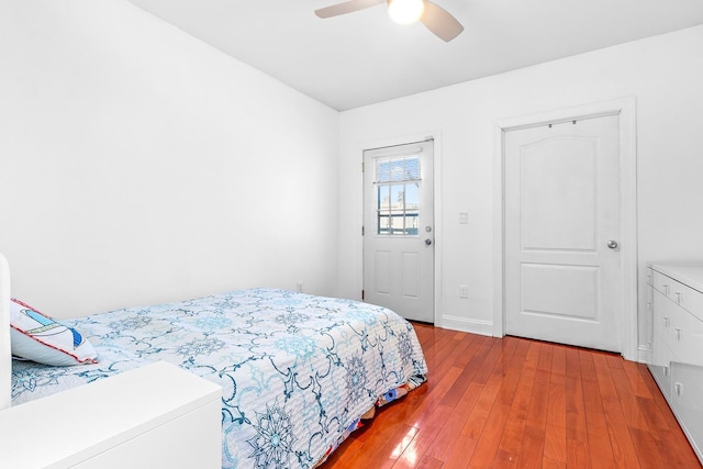 bedroom with a ceiling fan, baseboards, and wood-type flooring