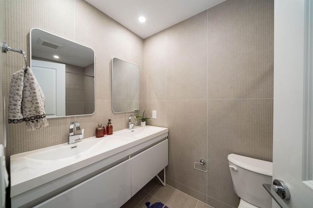 bathroom featuring backsplash, tile patterned floors, vanity, tile walls, and toilet