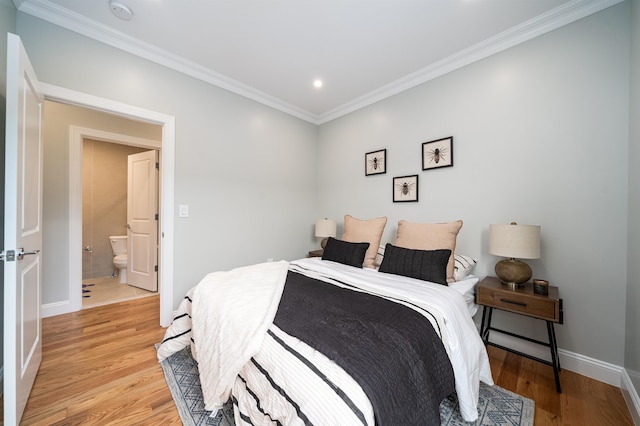 bedroom featuring ornamental molding, connected bathroom, and light hardwood / wood-style flooring