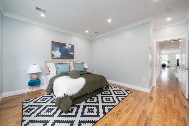 bedroom featuring crown molding and light wood-type flooring