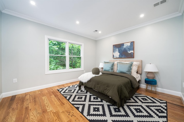 bedroom with hardwood / wood-style floors and ornamental molding