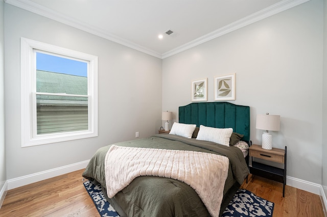 bedroom with light hardwood / wood-style floors and ornamental molding