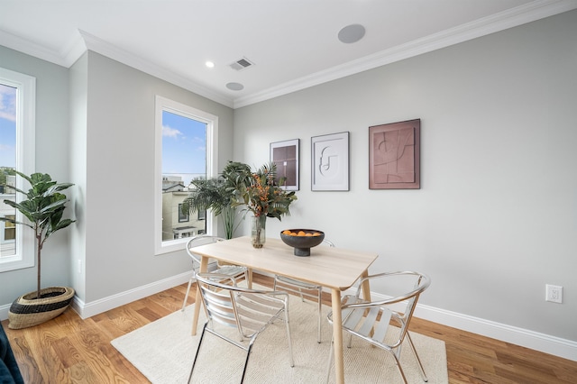 dining room with hardwood / wood-style floors and crown molding