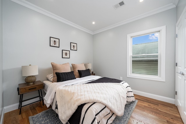 bedroom featuring wood-type flooring and ornamental molding