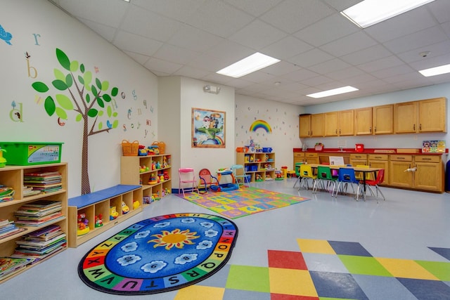 playroom with a paneled ceiling and tile patterned floors